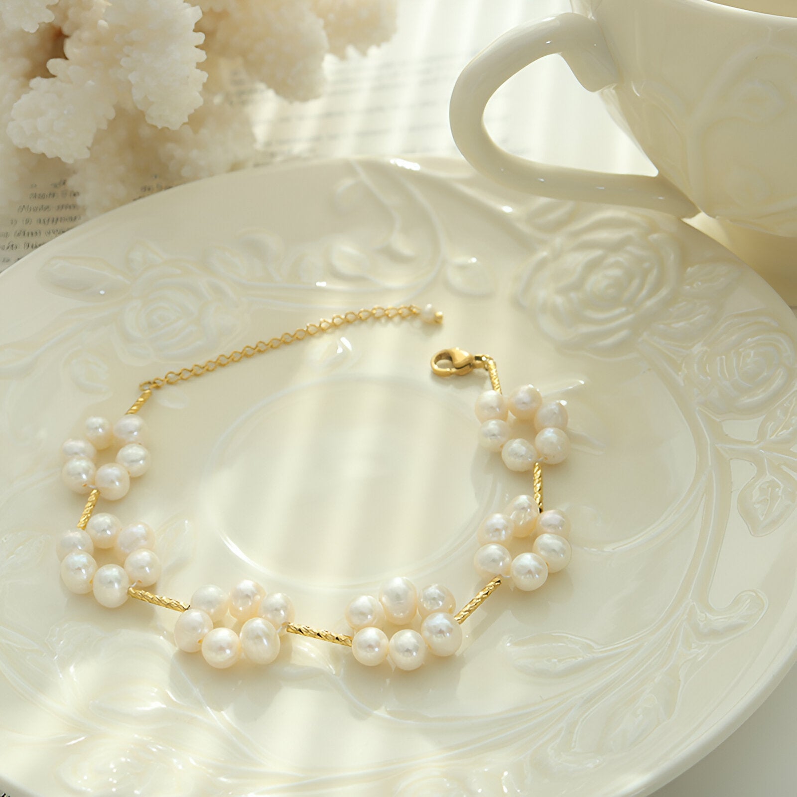Bracelet doré en titane or 18 carats avec fleurs en perles naturelles fines sur chaîne délicate.