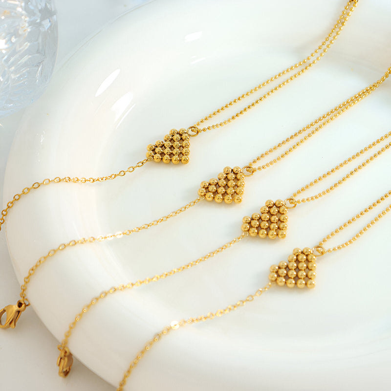 Bracelets en titane plaqué or avec motif cœur perlé sur chaîne fine délicate.