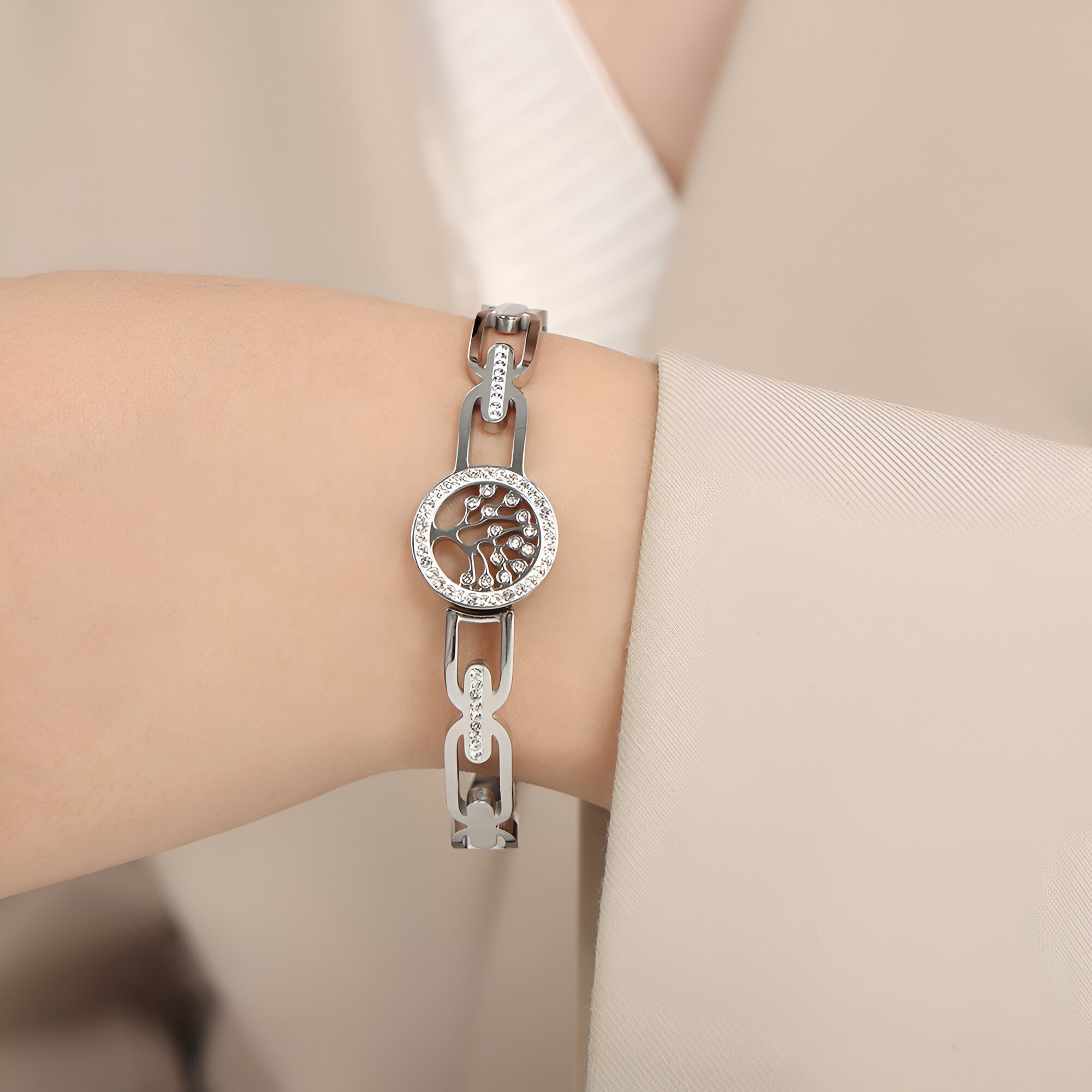 Bracelet en titane argenté pour femme avec motif arbre de vie et strass scintillants autour du cadran rond.