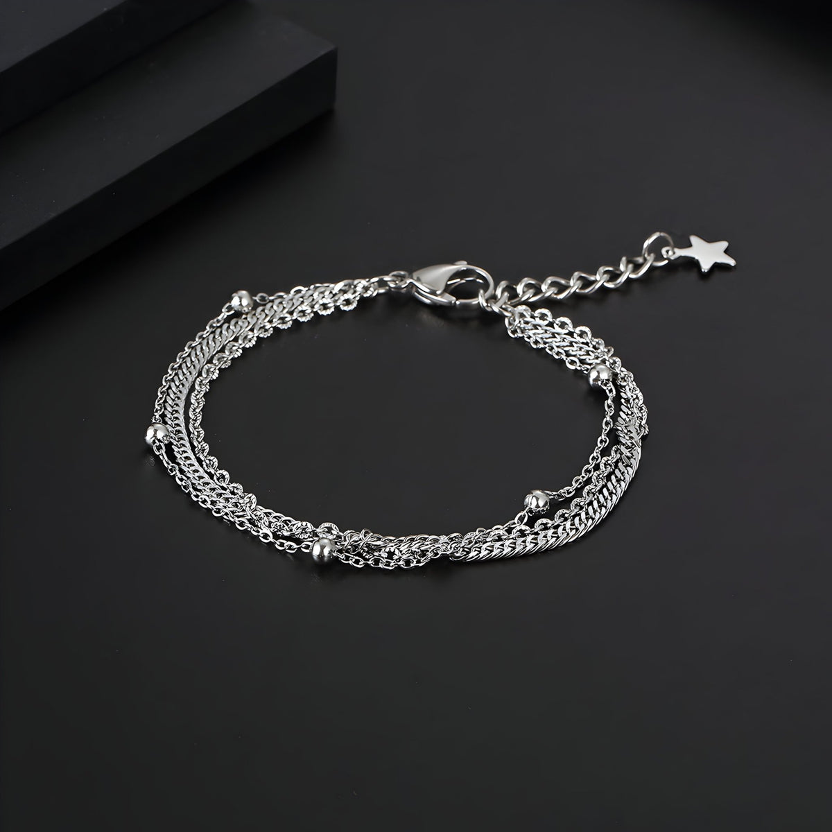 Bracelet triple en titane argenté pour homme avec petites perles et fermoir étoile.