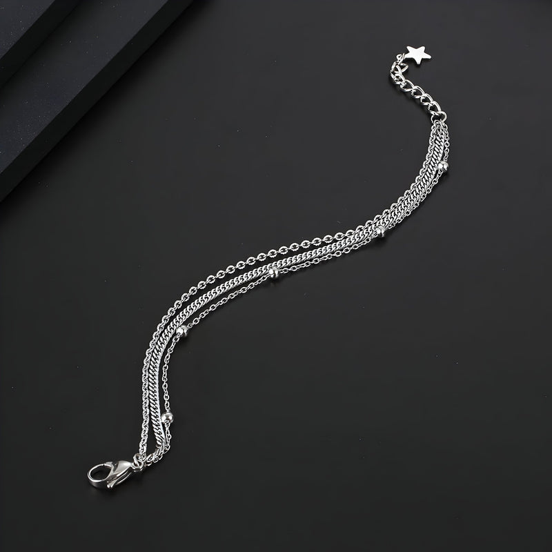 Bracelet homme triple en titane argenté avec chaînes fines et fermoir étoile sécurisé.