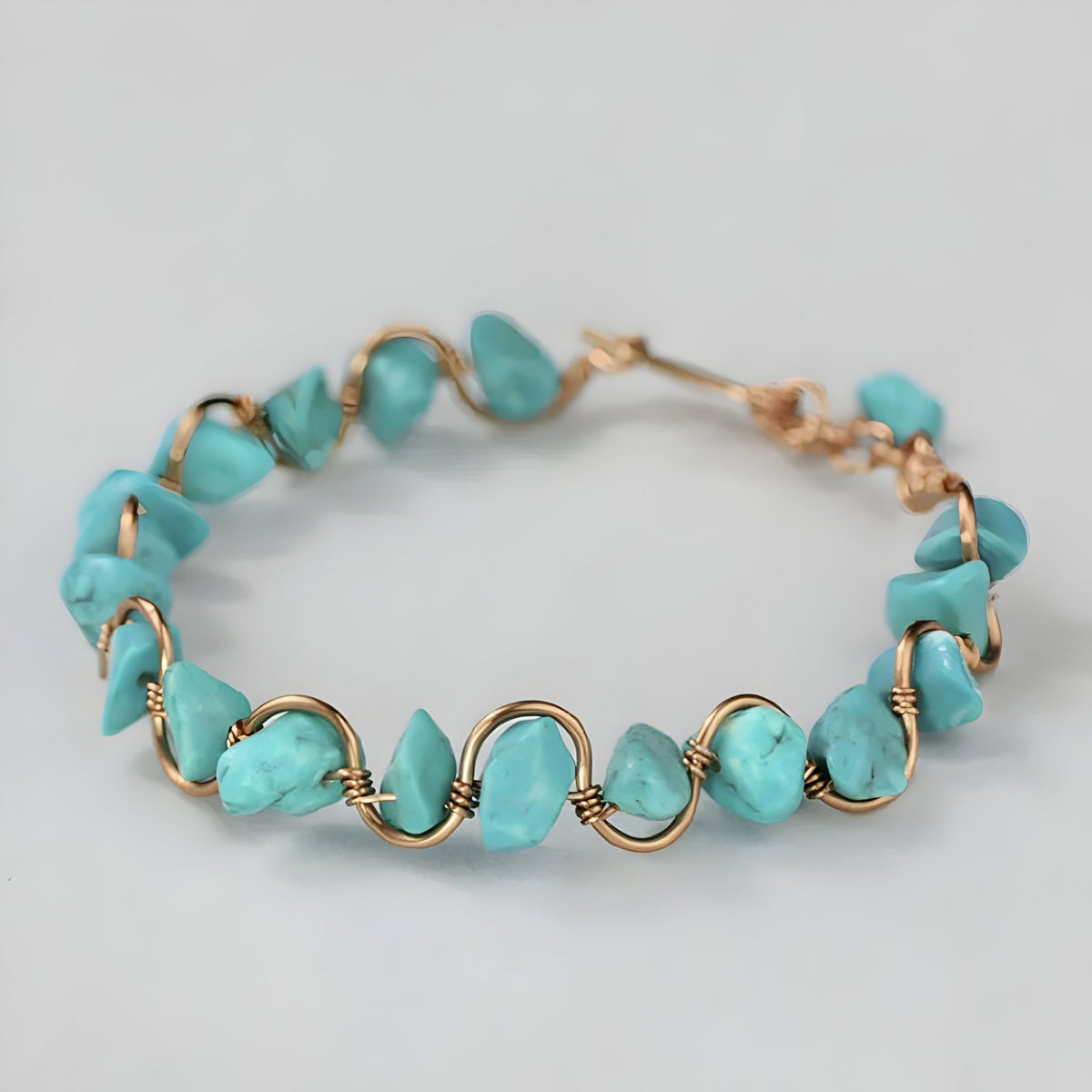 Bracelet femme en cuivre doré avec pierres turquoise irrégulières et fermoir à crochet.
