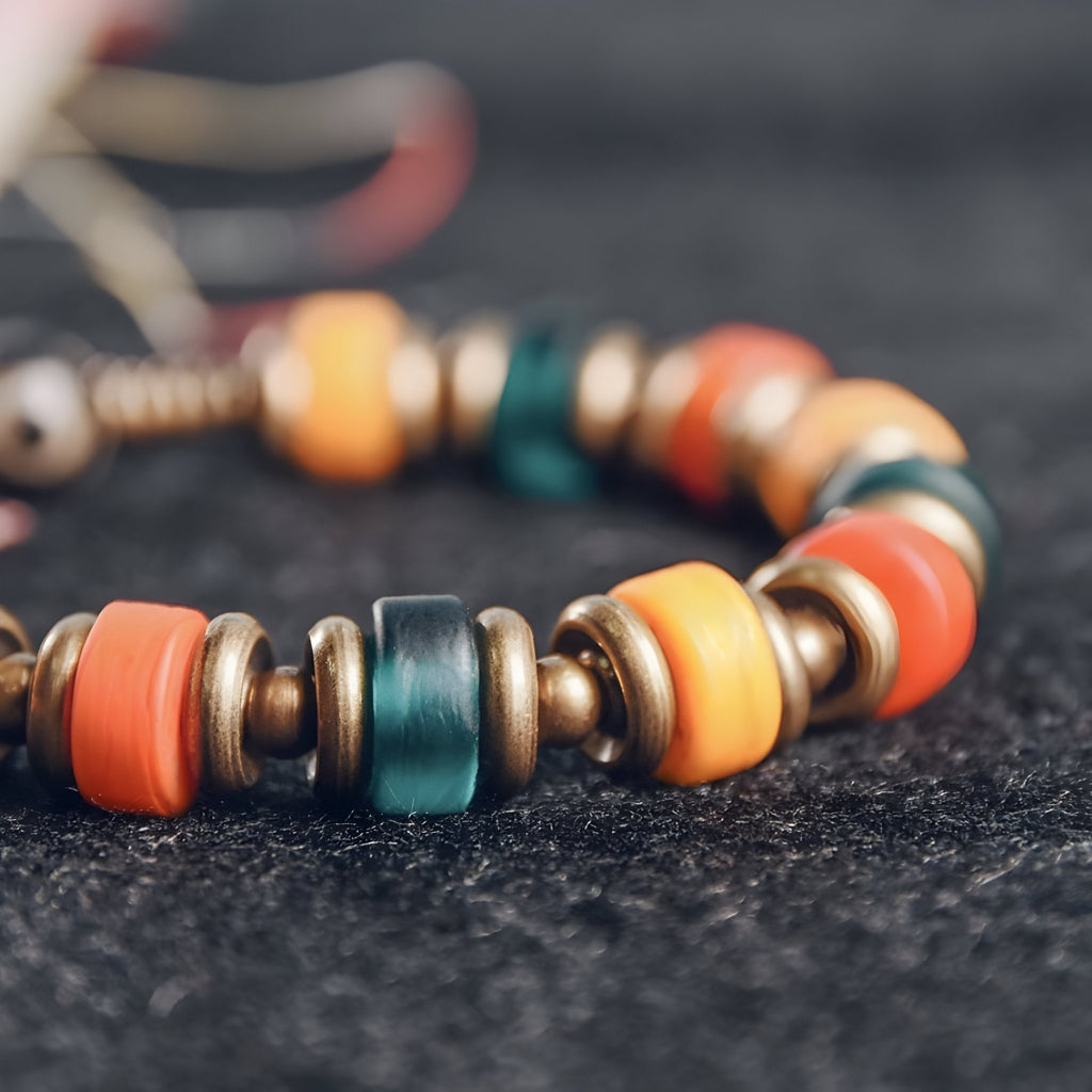 Bracelet femme en cuivre avec perles en verre multicolores orange, vert, jaune et bronze sur corde réglable.