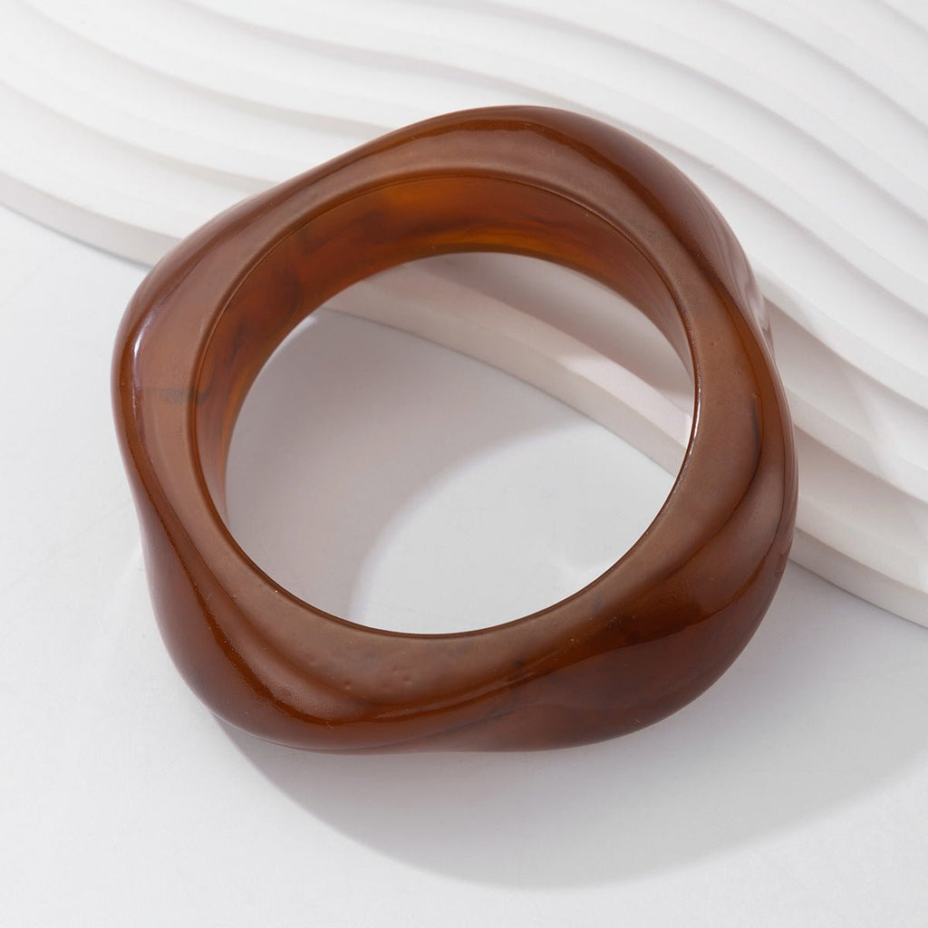 Bracelet épais carré en acrylique marron translucide aux bords arrondis, style moderne et élégant.