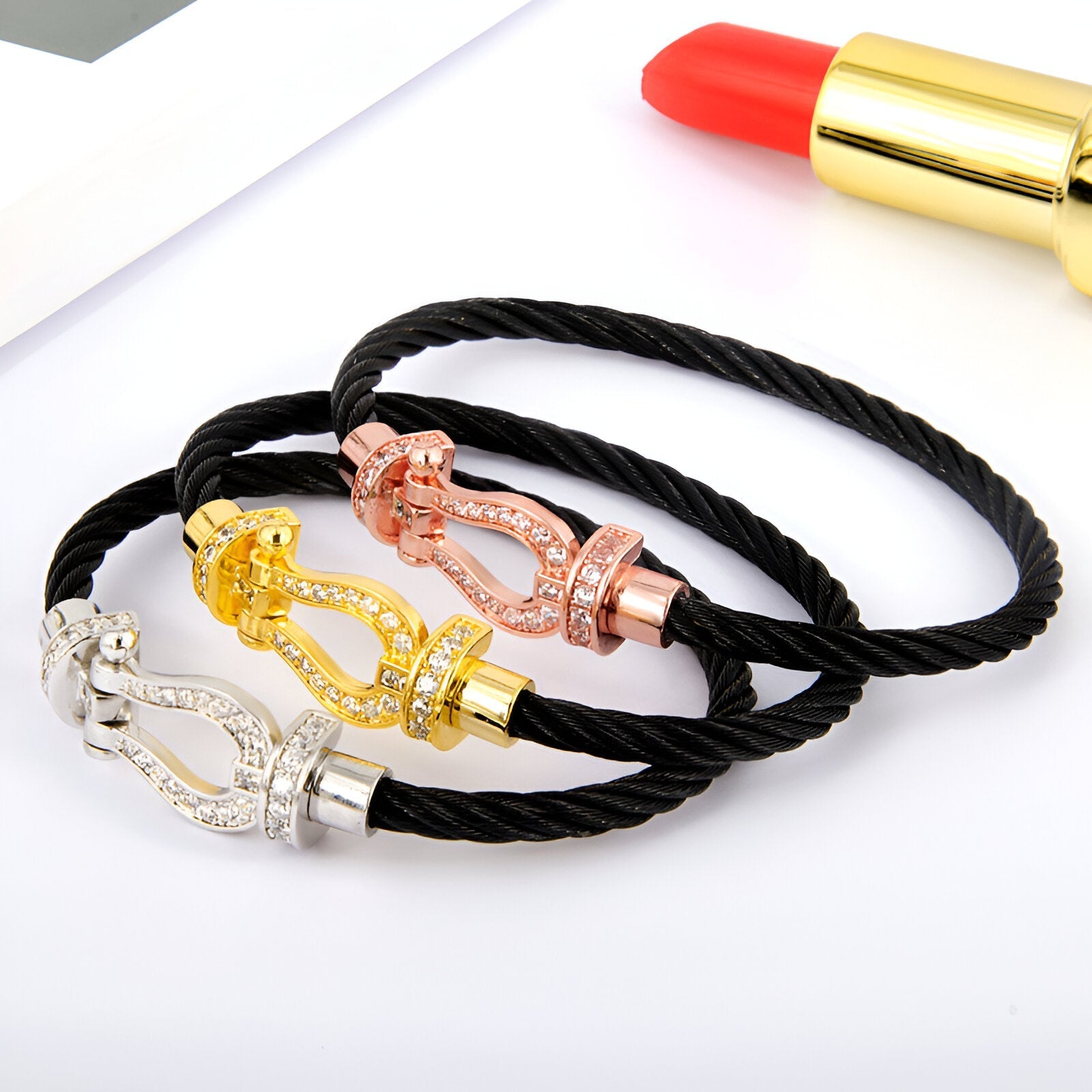 Bracelet femme cordon titane noir avec fer à cheval or, or rosé et argent décoré de strass.