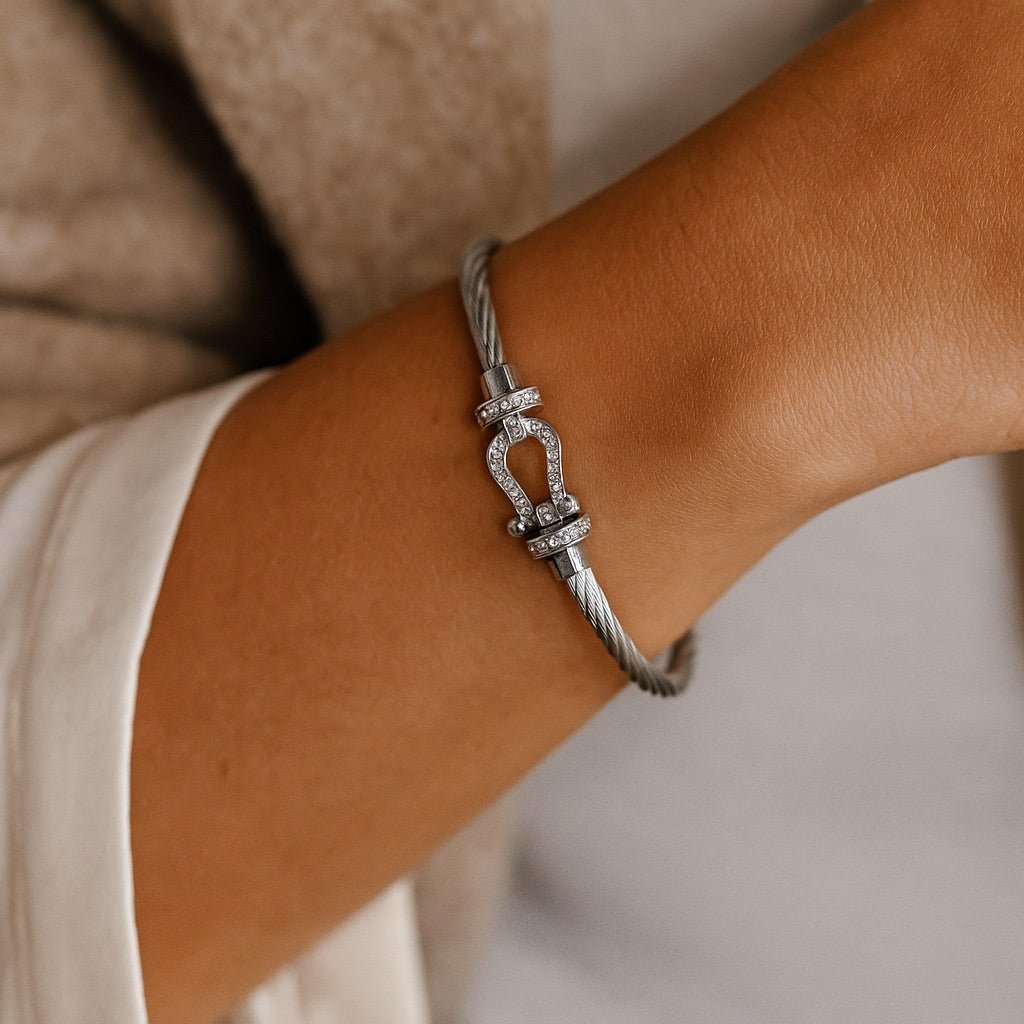 Bracelet fer à cheval en titane gris avec détail en argent brillant, style minimaliste féminin.