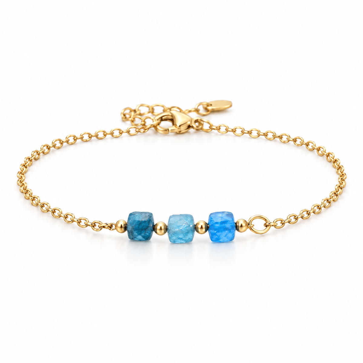 Packshot studio bracelet Bracelet fin en acier doré, maille forçat, trois pierres naturelles facettées, bijou élégant et lumineux, modèle Ilumia — Apatite bleu, vue frontale basse, fond blanc pur, détails verrouillés
