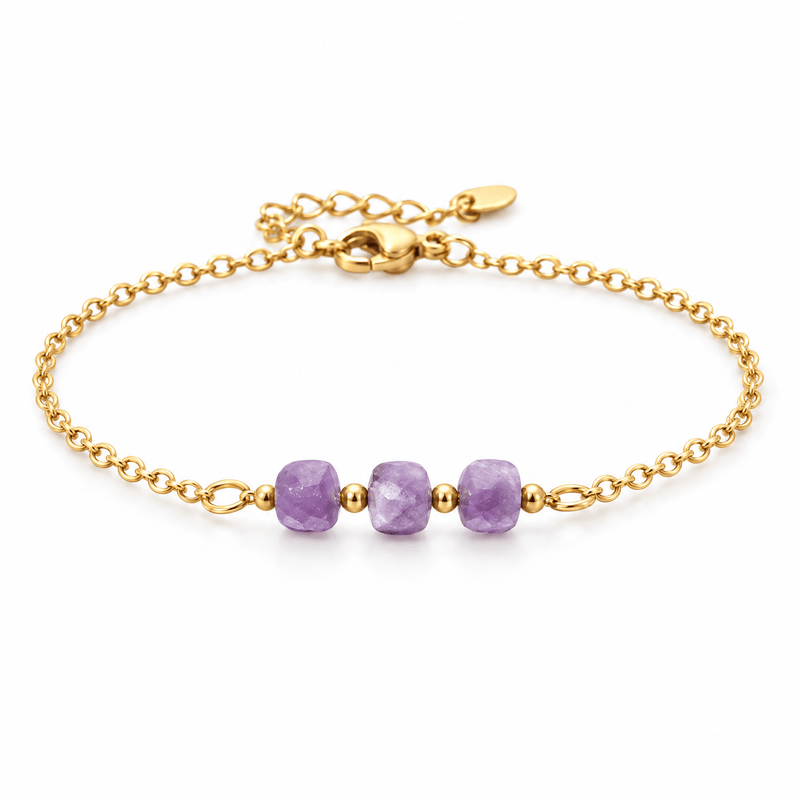 Packshot studio bracelet Bracelet fin en acier doré, maille forçat, trois pierres naturelles facettées, bijou élégant et lumineux, modèle Ilumia — Améthyste, vue frontale basse, fond blanc pur, détails verrouillés