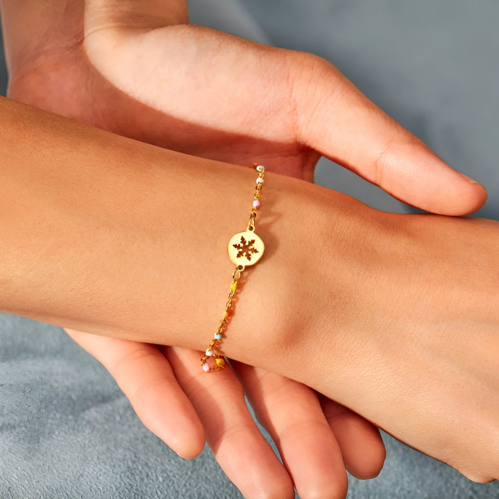 Bracelet fin en or avec pendentif flocon de neige, style délicat pour femme.