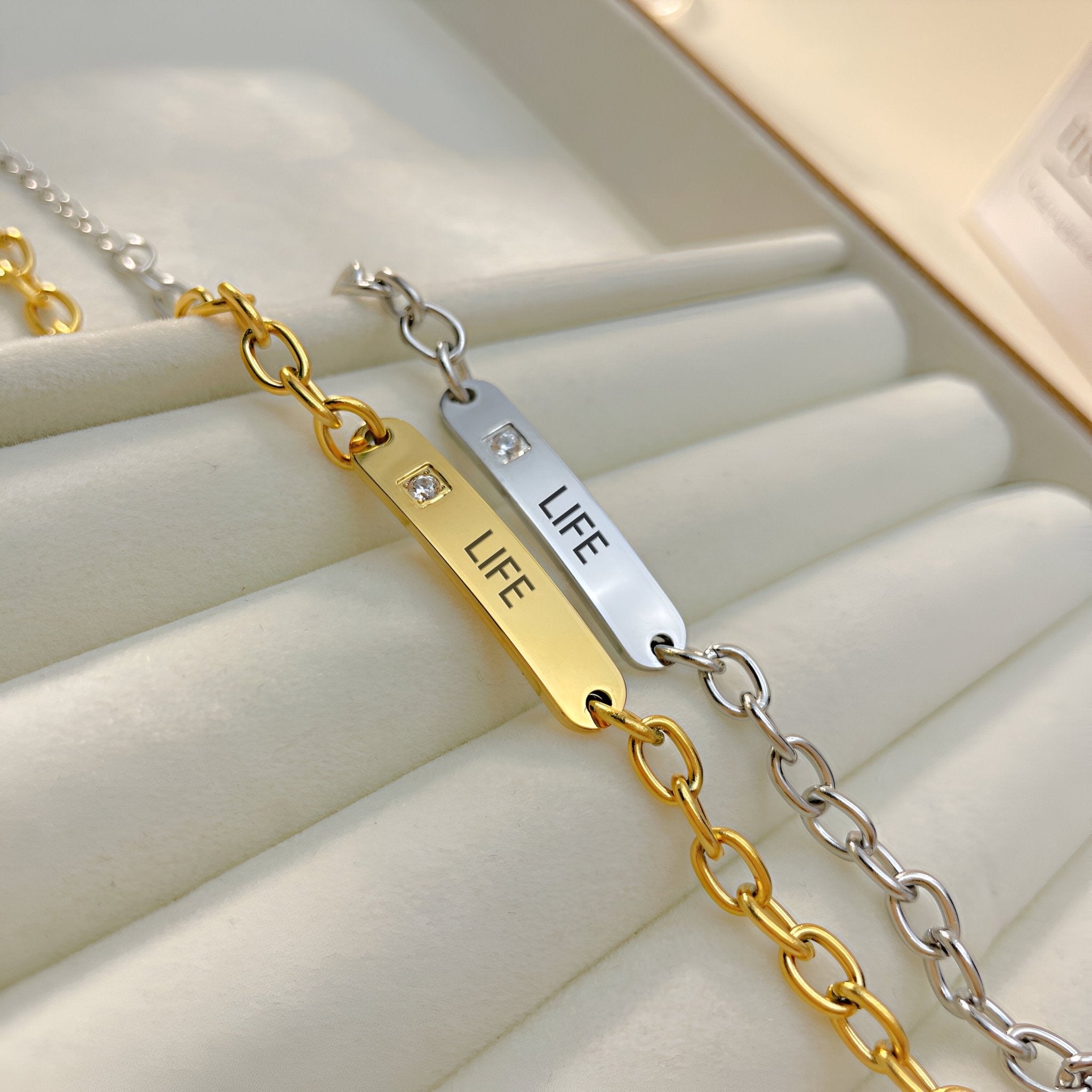 Bracelet gourmette en acier inoxydable or avec plaque gravée LIFE et pierre zirconium, chaîne maillons ovales; version.
