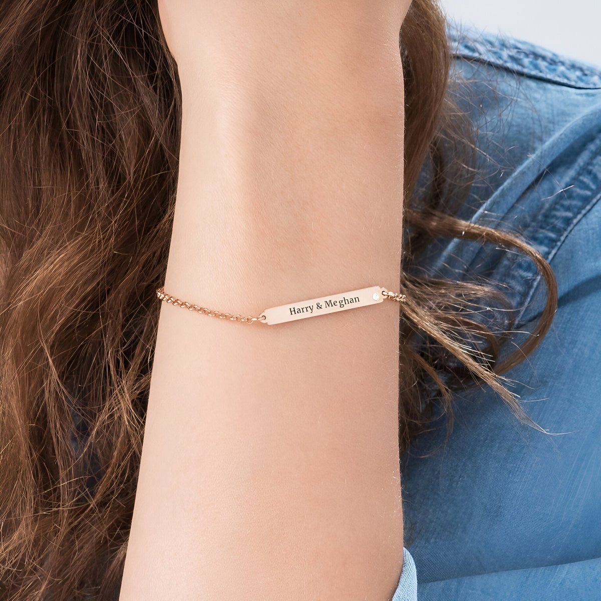 Bracelet gourmette en argent sterling avec plaque personnalisée et zircons scintillants, porté au poignet féminin.