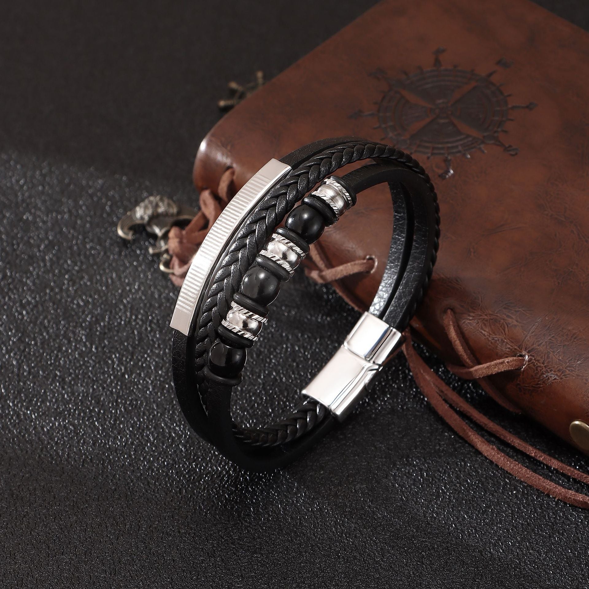 Bracelet homme multi-rangs en cuir noir tressé avec perles onyx noires et fermoir magnétique argenté gravé.