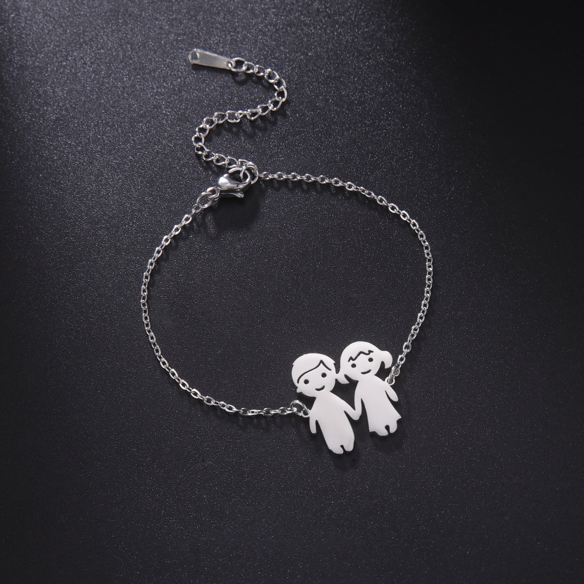 Bracelet fin en acier inoxydable argenté avec pendentif couple stylisé homme et femme.