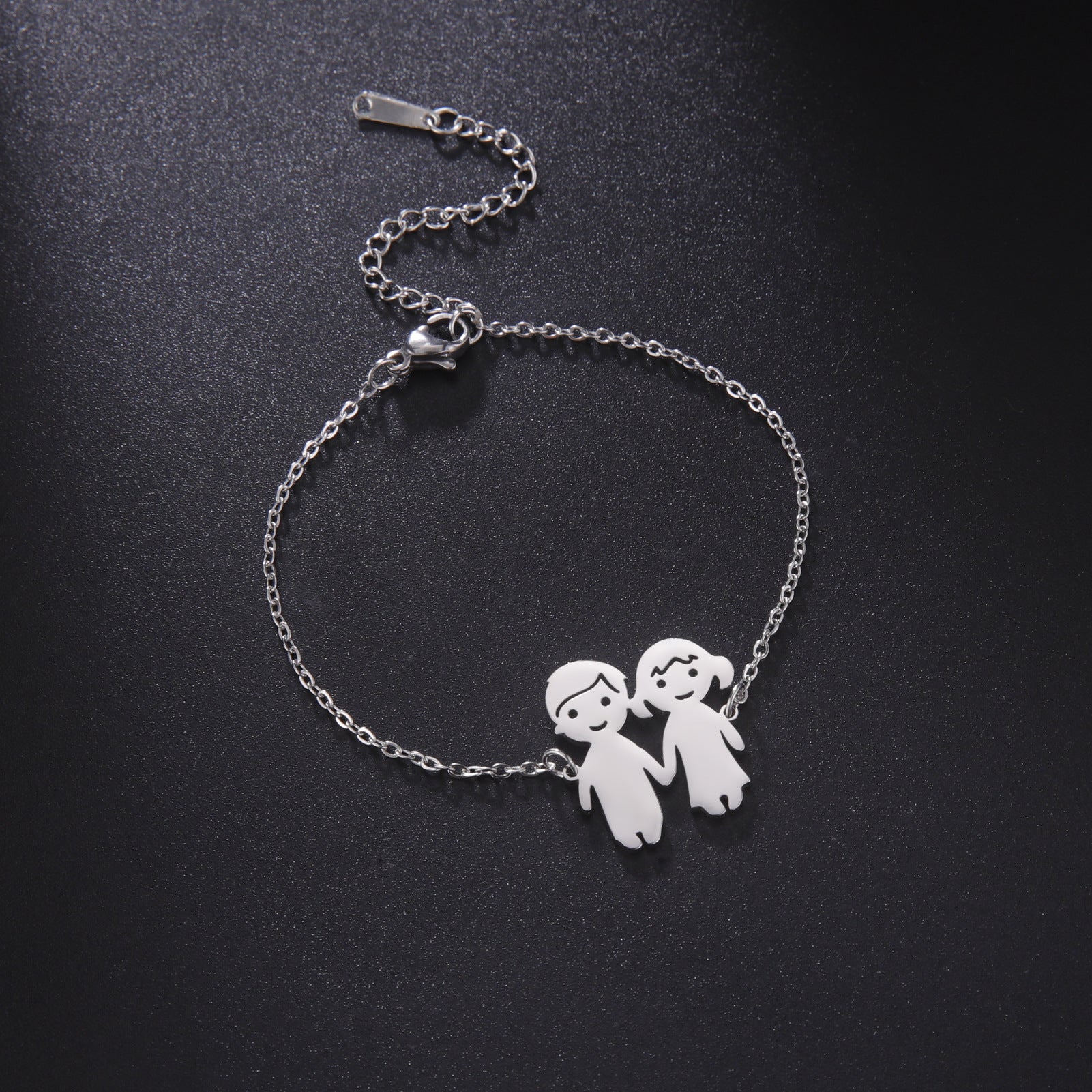 Bracelet fin en acier inoxydable argenté avec pendentif couple stylisé homme et femme.
