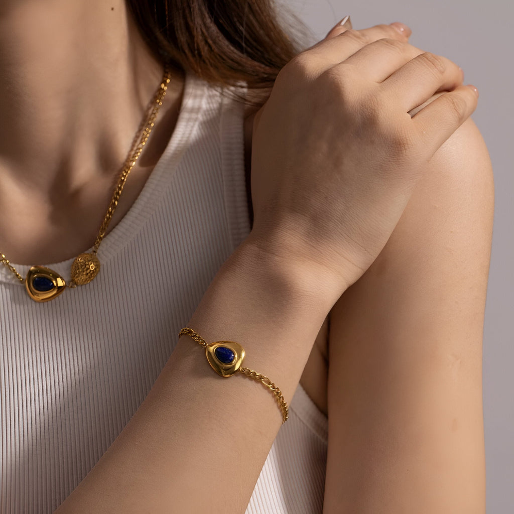 Bracelet doré en acier avec pierre de lapis lazuli ronde sur chaîne fine, style élégant féminine.