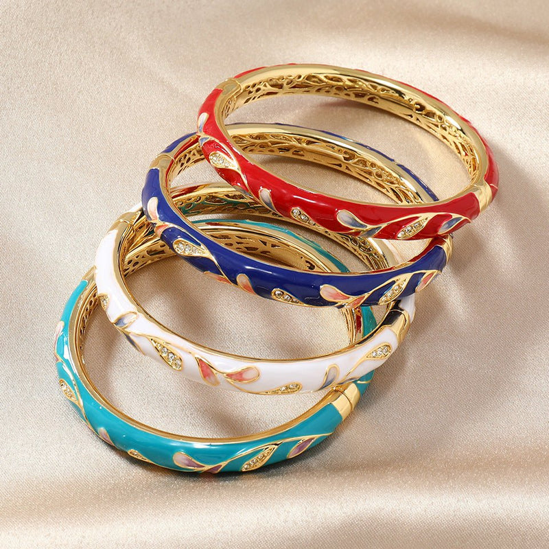 Bracelets joncs en cuivre plaqué or avec motifs floraux scintillants en rouge, bleu foncé, blanc, bleu ciel et vert.