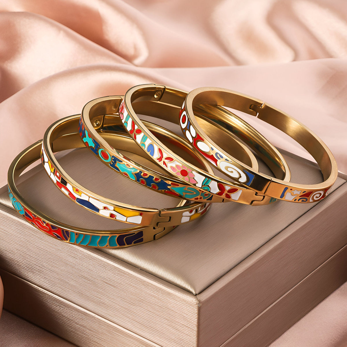 Ensemble de bracelets joncs fins en métal doré et émail coloré avec motifs géométriques variés.