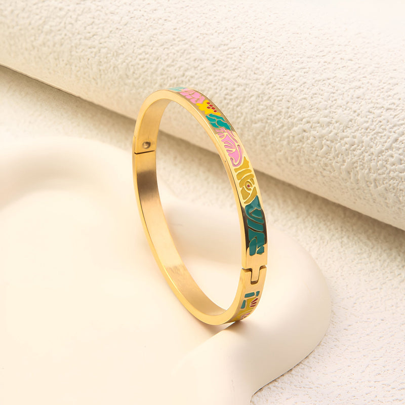 Bracelet jonc en métal doré avec émail coloré motifs abstraits verts, roses et jaunes.