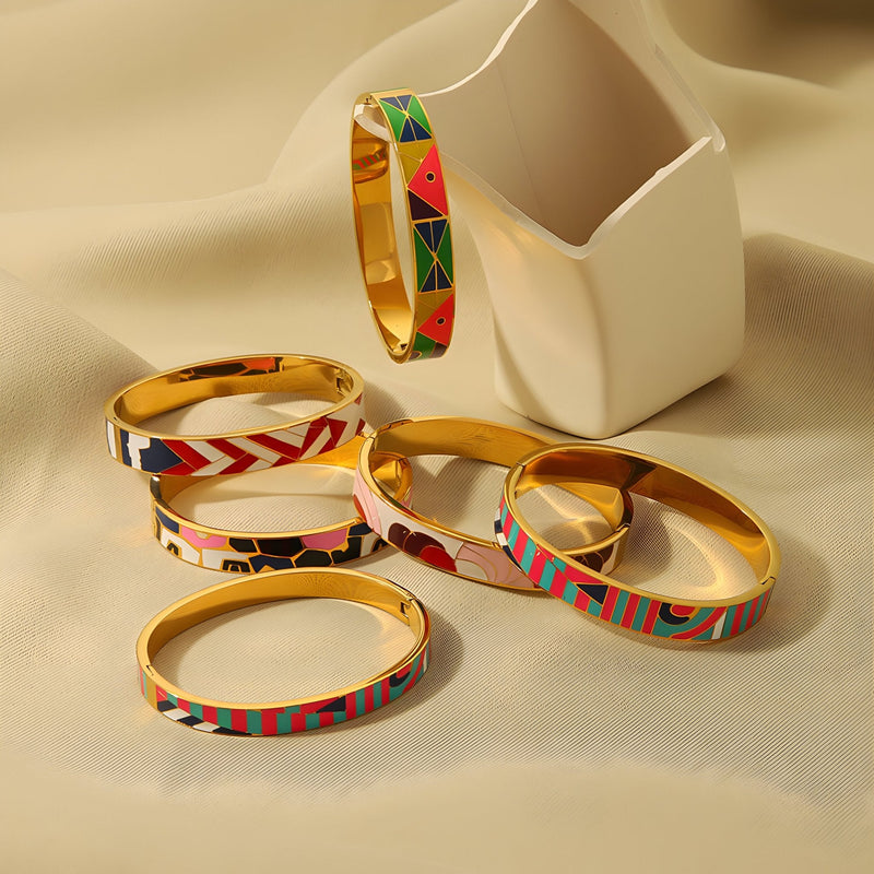 Set de six bracelets joncs en métal doré avec motifs émaillés colorés et abstraits, style moderne féminin.