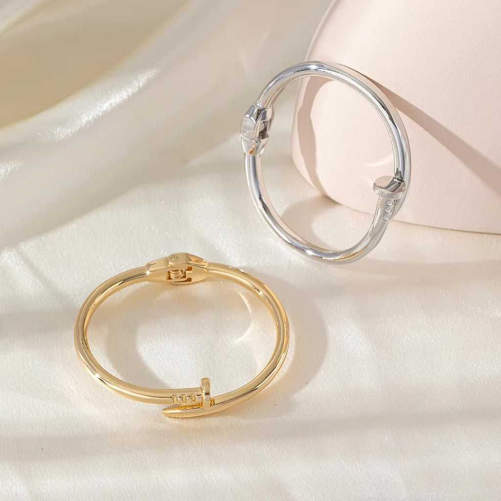 Bracelet jonc clou argenté et doré en acier inoxydable, design minimaliste et élégant pour femme.