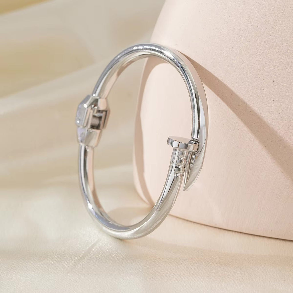 Bracelet jonc argenté en acier inoxydable avec détails clou moderne pour femme, modèle Amparo.