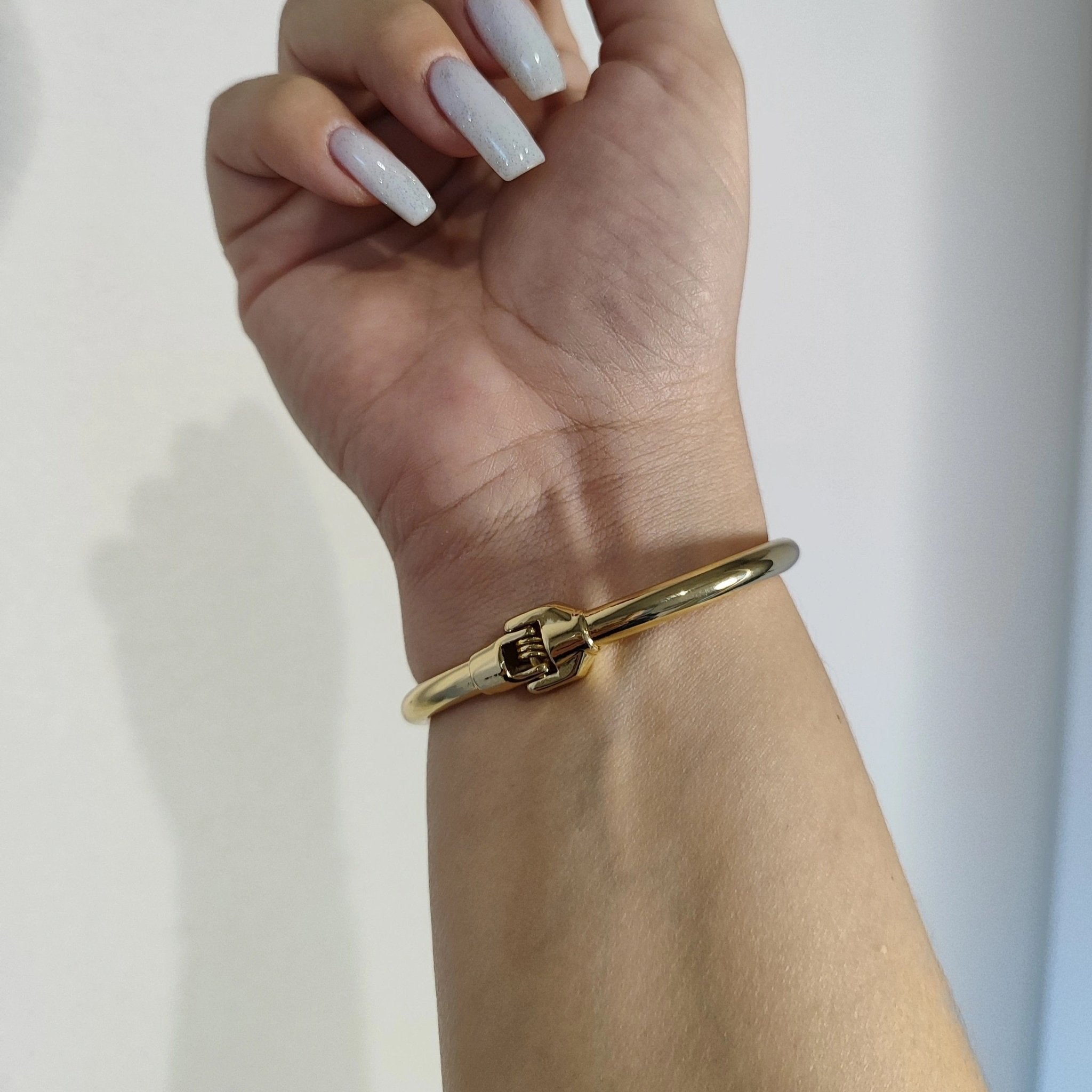 Bracelet jonc fin doré en acier inoxydable avec détail clou élégant pour femme.
