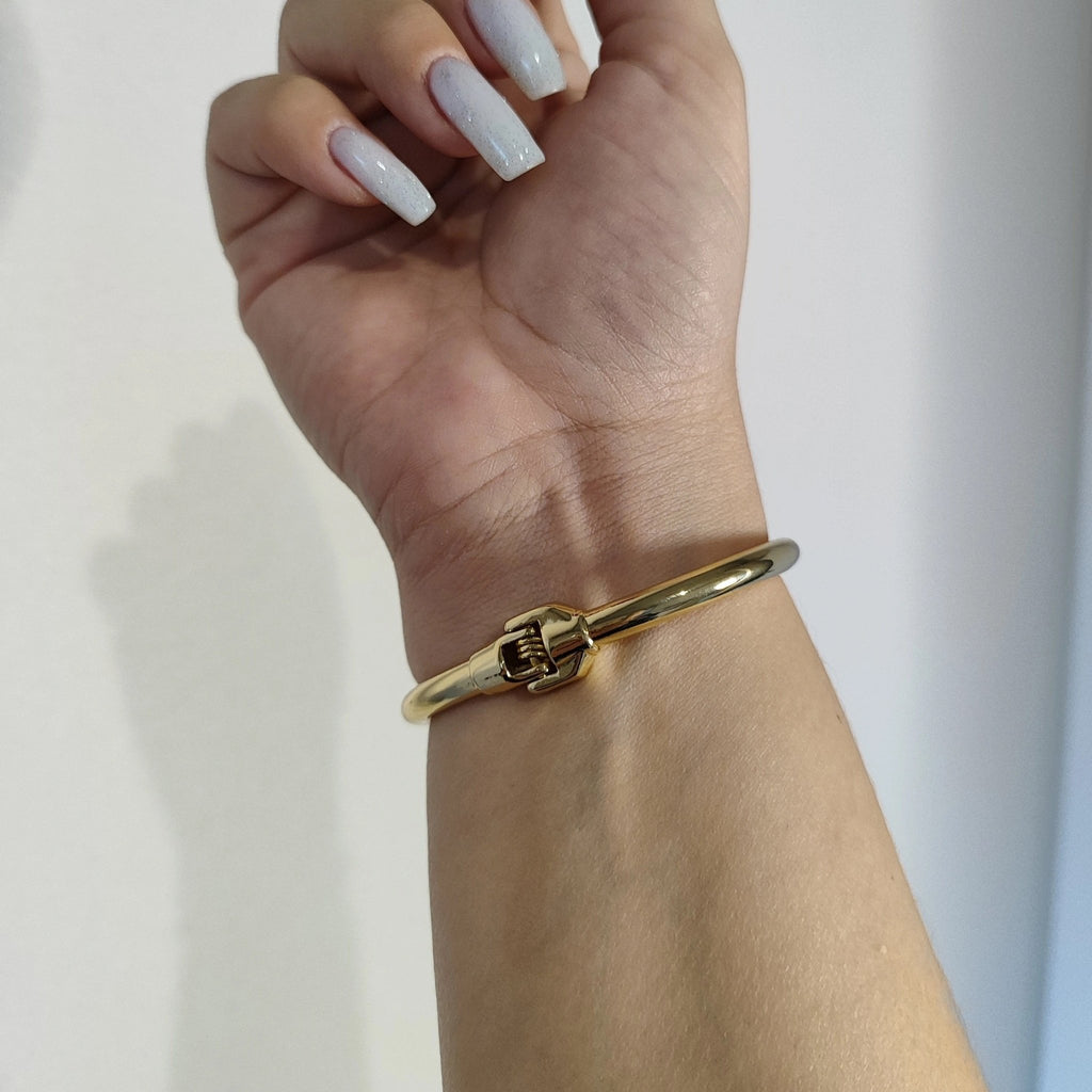 Bracelet jonc fin doré en acier inoxydable avec détail clou élégant pour femme.