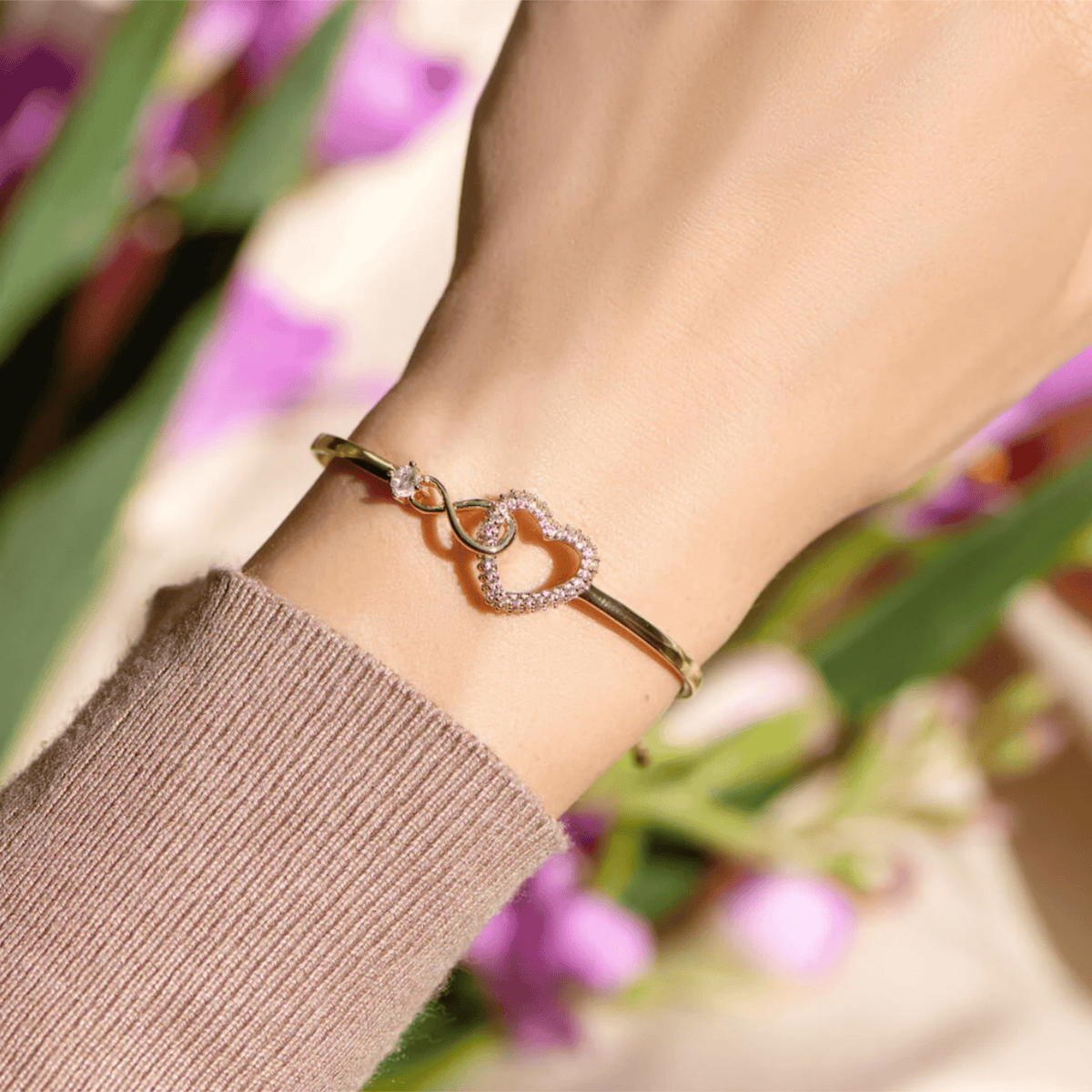 Bracelet jonc doré en acier inoxydable avec cœur infini orné d’une pierre zircon scintillante.