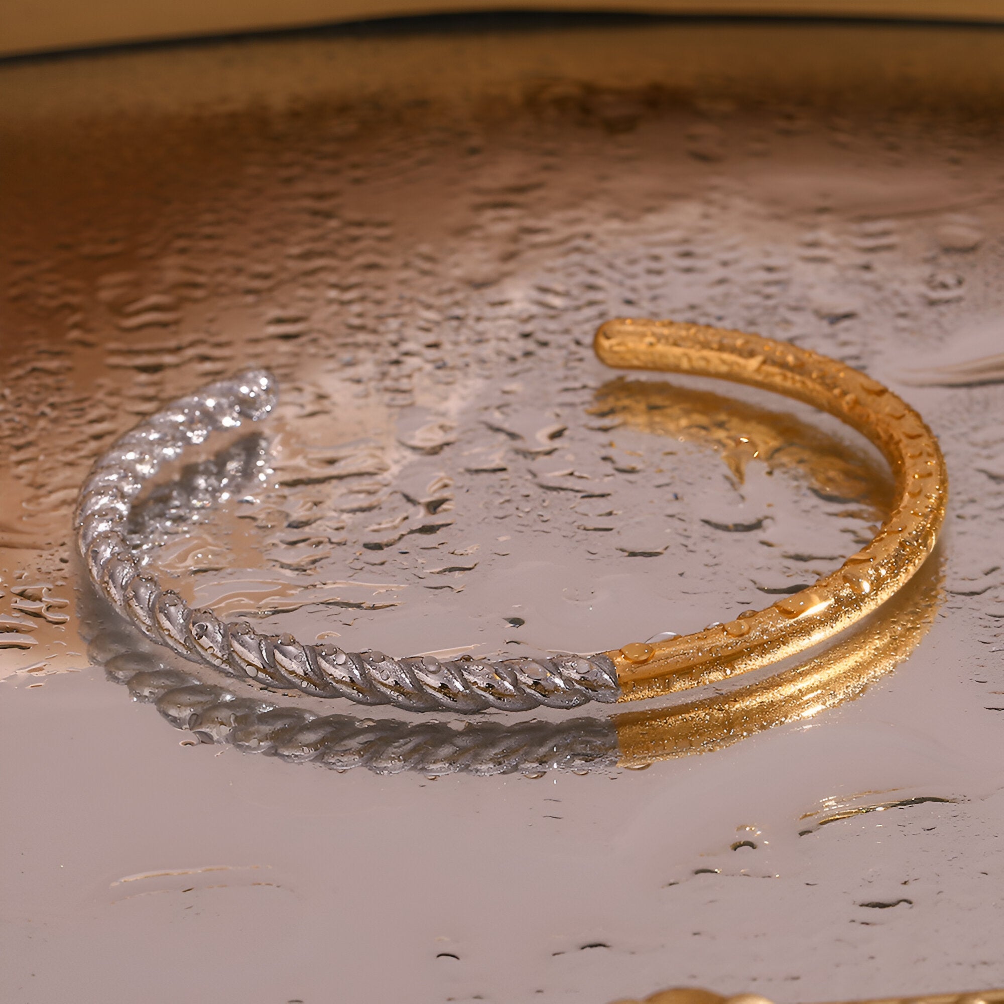 Bracelet jonc ouvert en acier inoxydable, moitié torsadé argenté, moitié lisse doré, style contemporain.