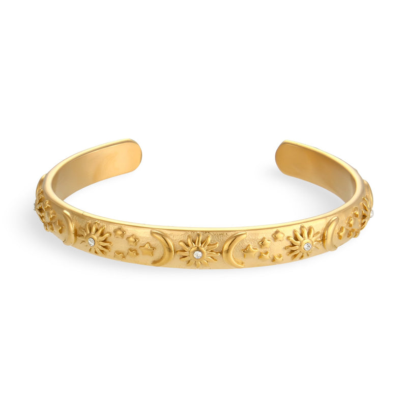 Bracelet jonc en acier inoxydable doré avec motifs célestes gravés et finition polie.