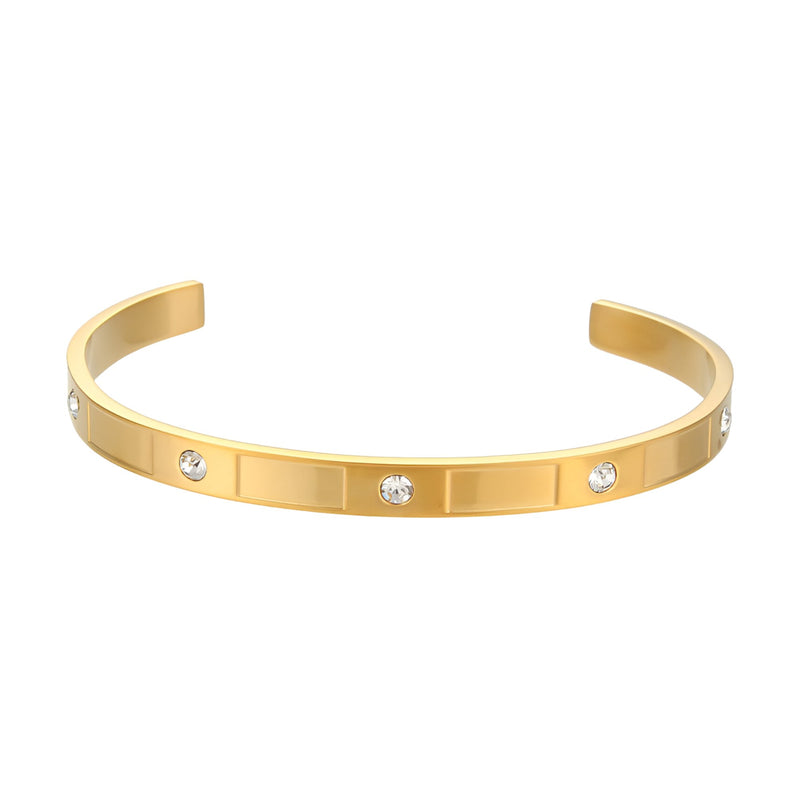 Bracelet jonc doré en acier inoxydable avec motifs géométriques et strass brillants.