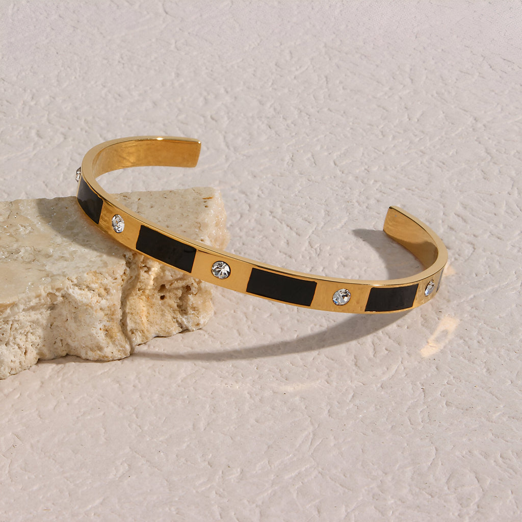 Bracelet jonc or en acier inoxydable avec inserts noirs et cristaux brillants design géométrique Gaïa.