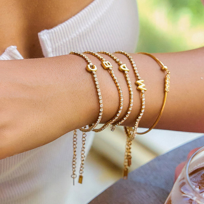 Bracelet jonc doré 18 carats avec lettres et zircons scintillants, finition chaîne ajustable.