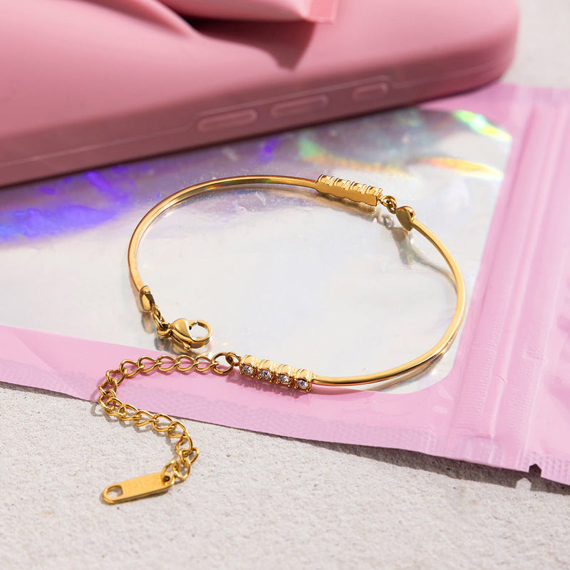 Bracelet jonc doré 18 carats fin avec cœur orné de zircons scintillants, fermoir mousqueton ajustable.