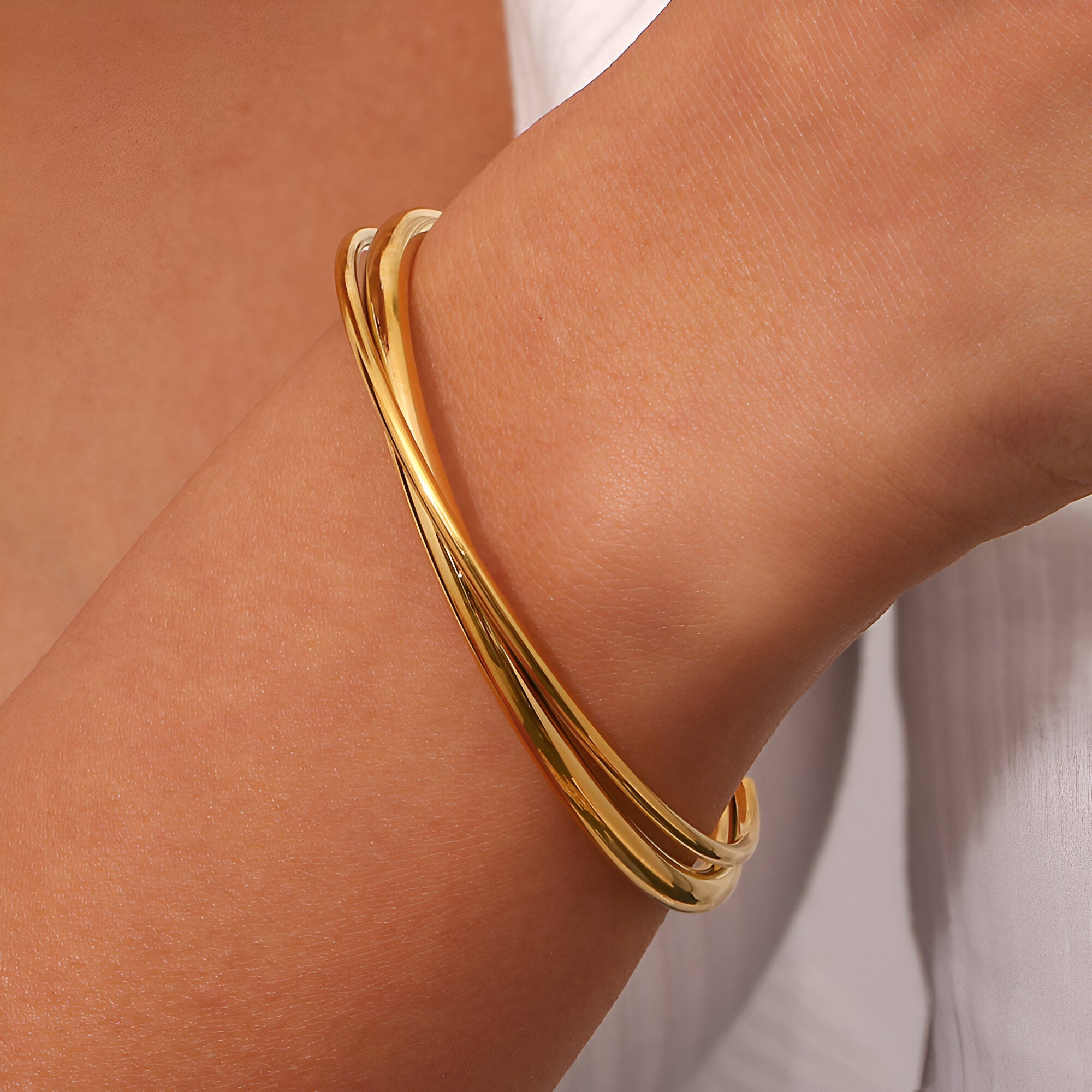 Bracelet jonc duo torsadé en acier inoxydable couleur or, style élégant et moderne.