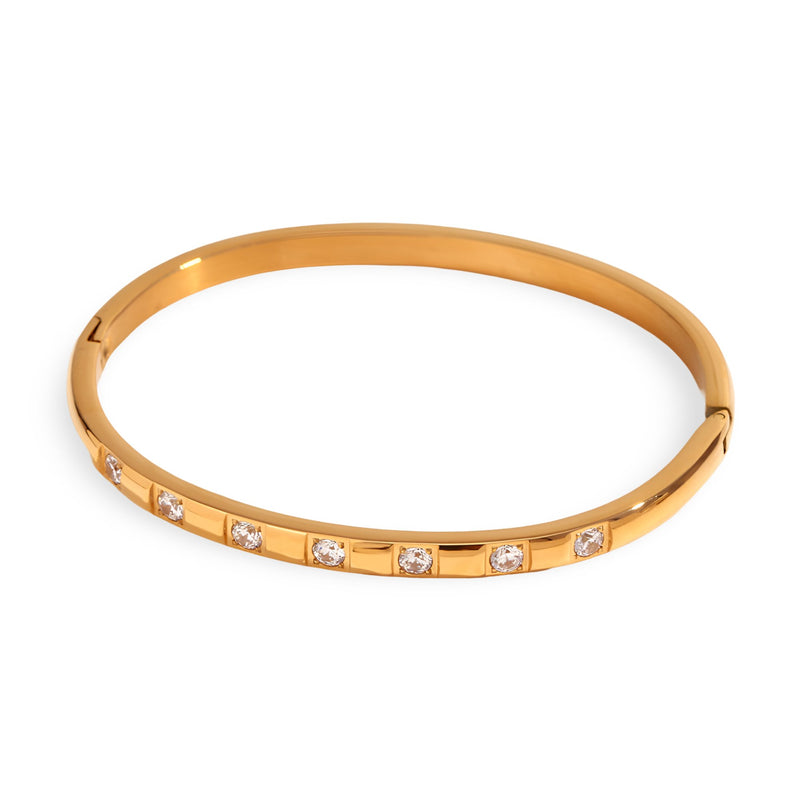 Bracelet jonc doré en acier inoxydable avec inserts en cristaux brillants, design fin et élégant.