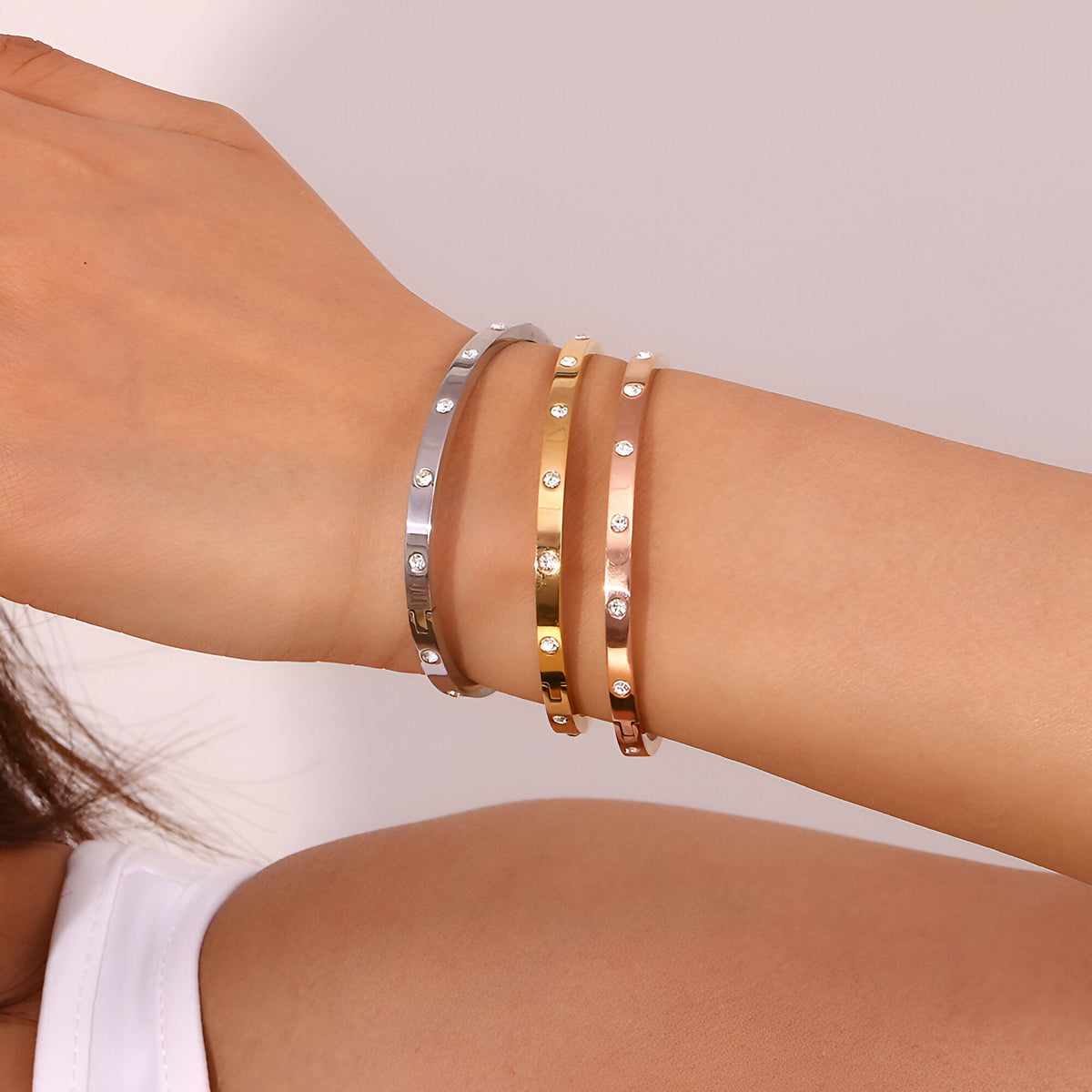 Bracelets joncs fins en acier inoxydable, tons or, or rosé et argent, finition éclats de lumière.