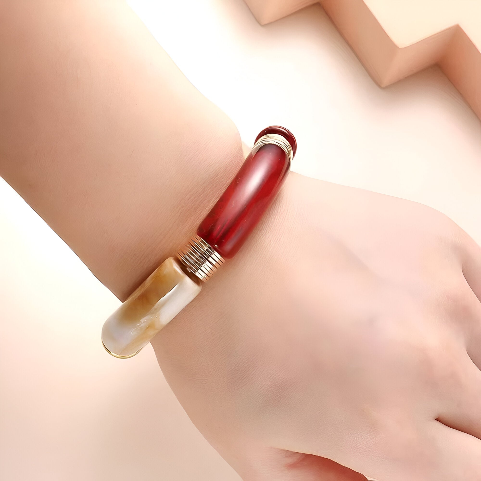 Bracelet jonc en acrylique bicolore marron et beige à détails argentés, design épuré et moderne.