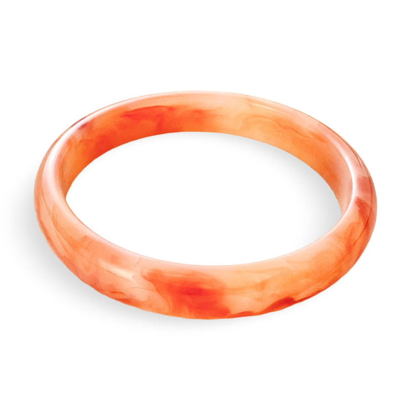 Bracelet jonc en acrylique orange marbré avec finition lisse et brillante.