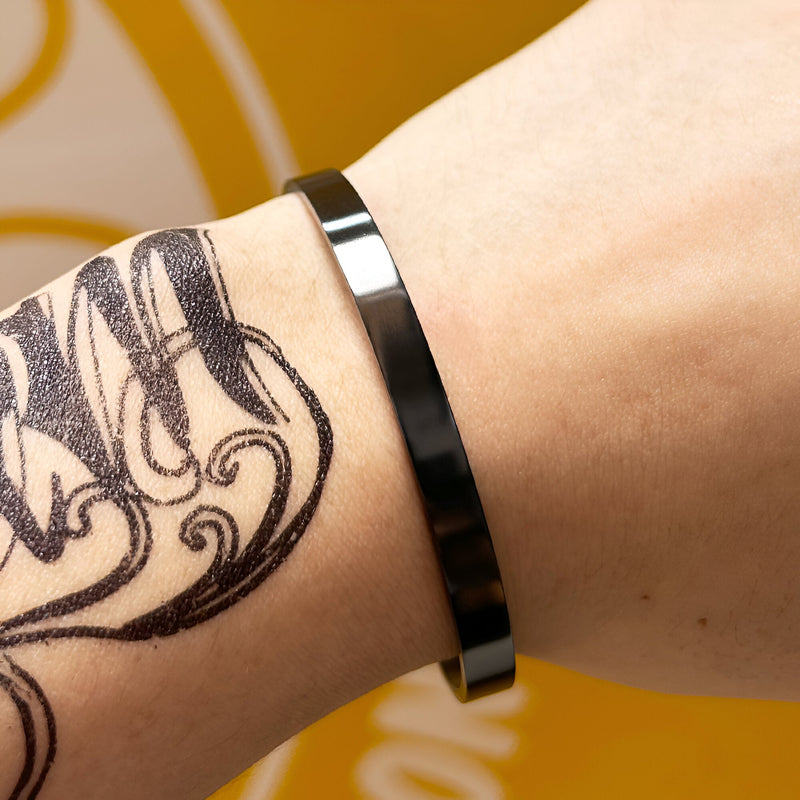 Bracelet jonc fin en acier inoxydable noir brillant pour homme, design épuré et tendance.