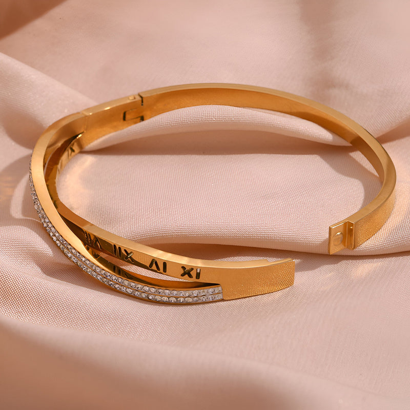 Bracelet jonc doré 18 carats avec inscription chiffres romains et rangée de petits cristaux.