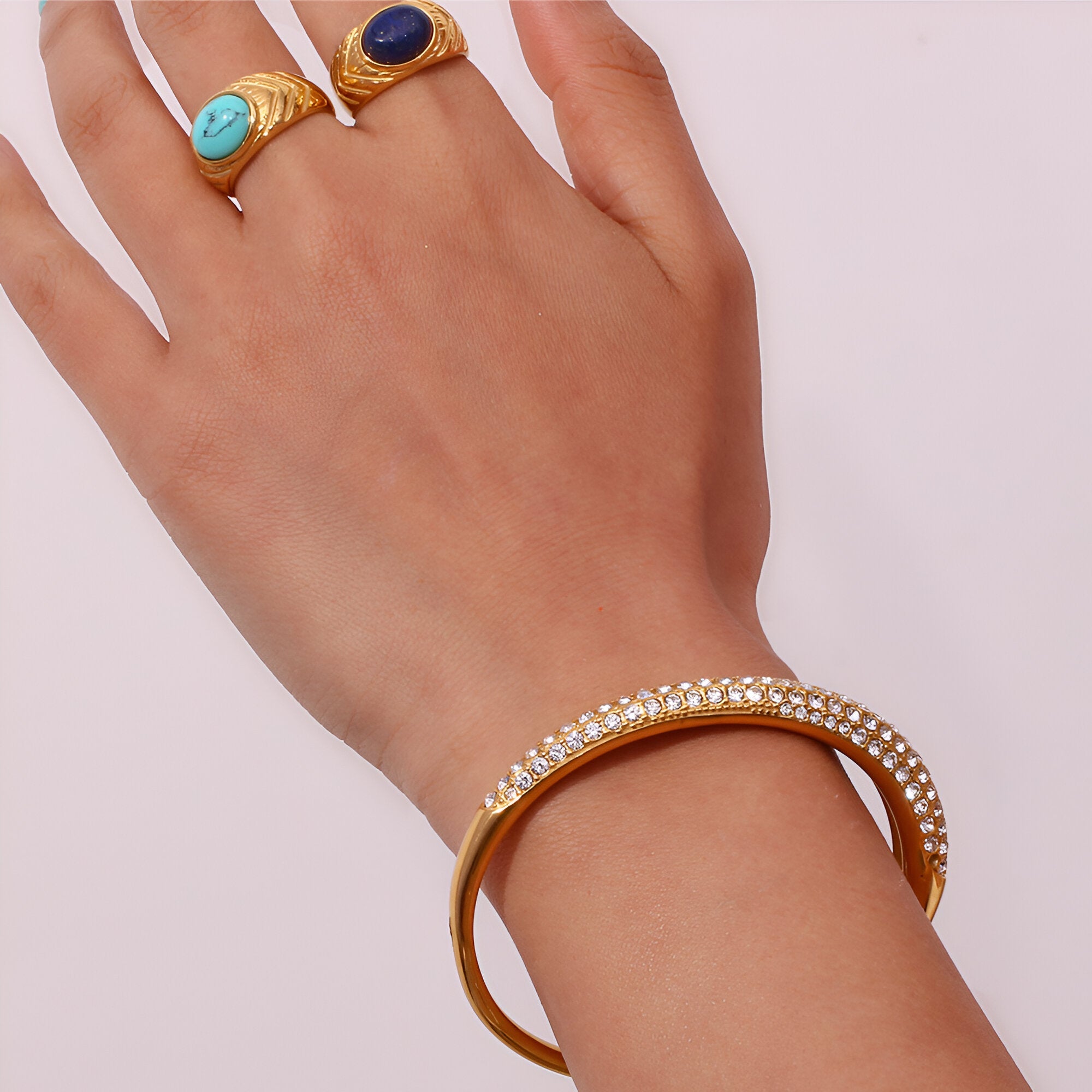 Bracelet jonc fin en acier inoxydable doré 18 carats serti de zircons brillants.