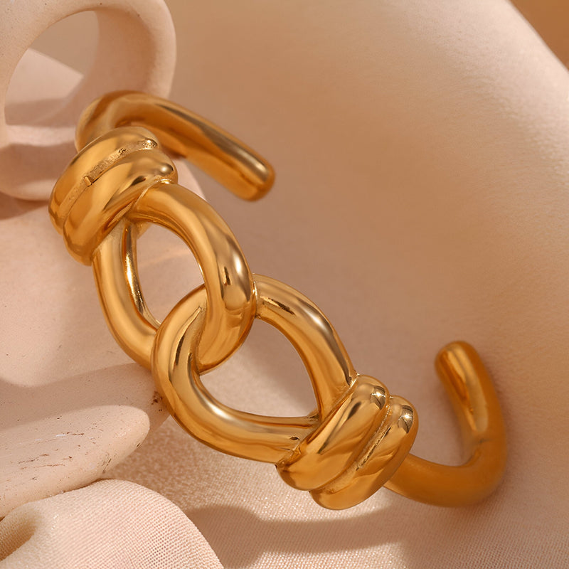 Bracelet jonc doré en acier inoxydable à motif de nœud d'agui élégant et poli.