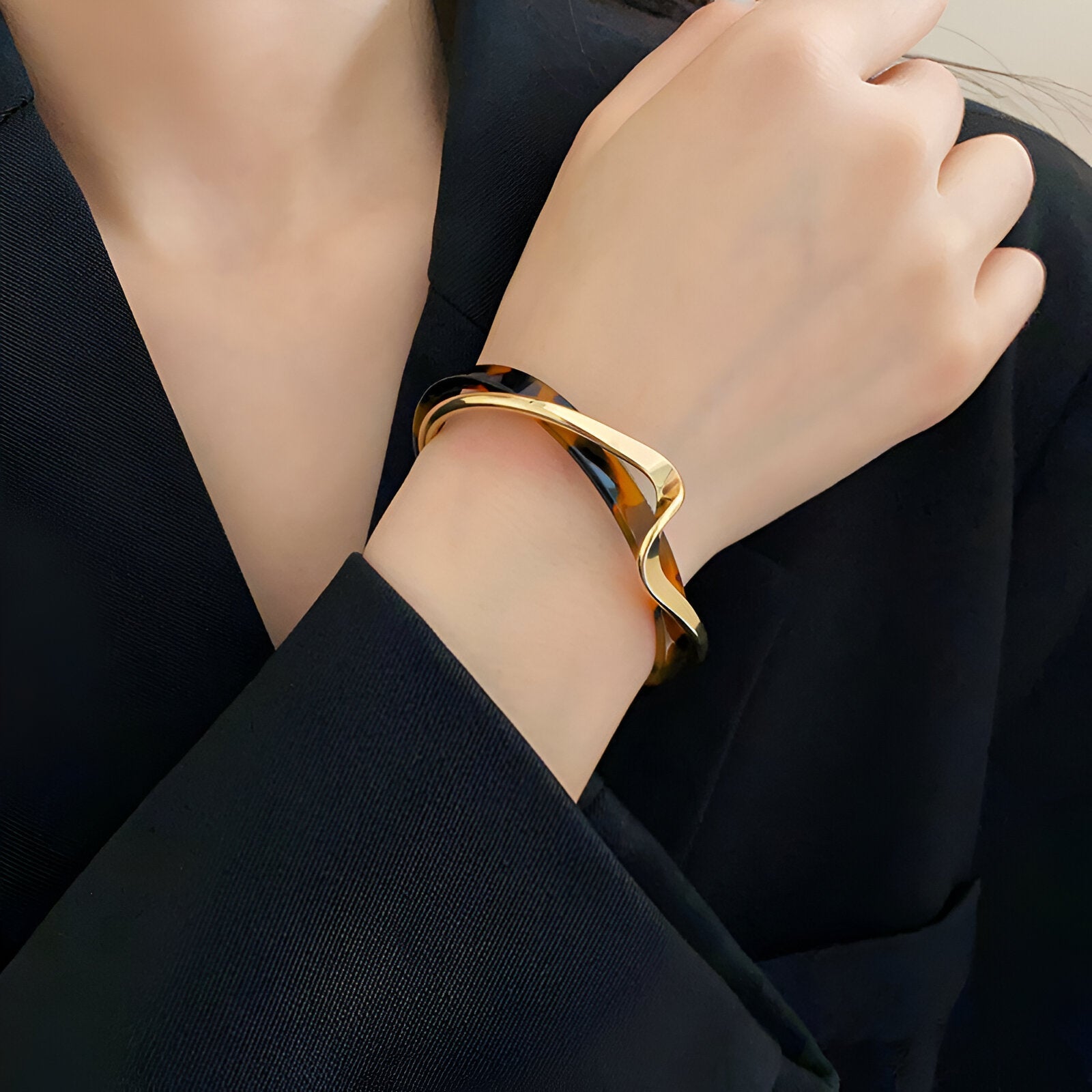 Bracelet jonc en acrylique et métal orné d'un motif léopard, style élégant et moderne.