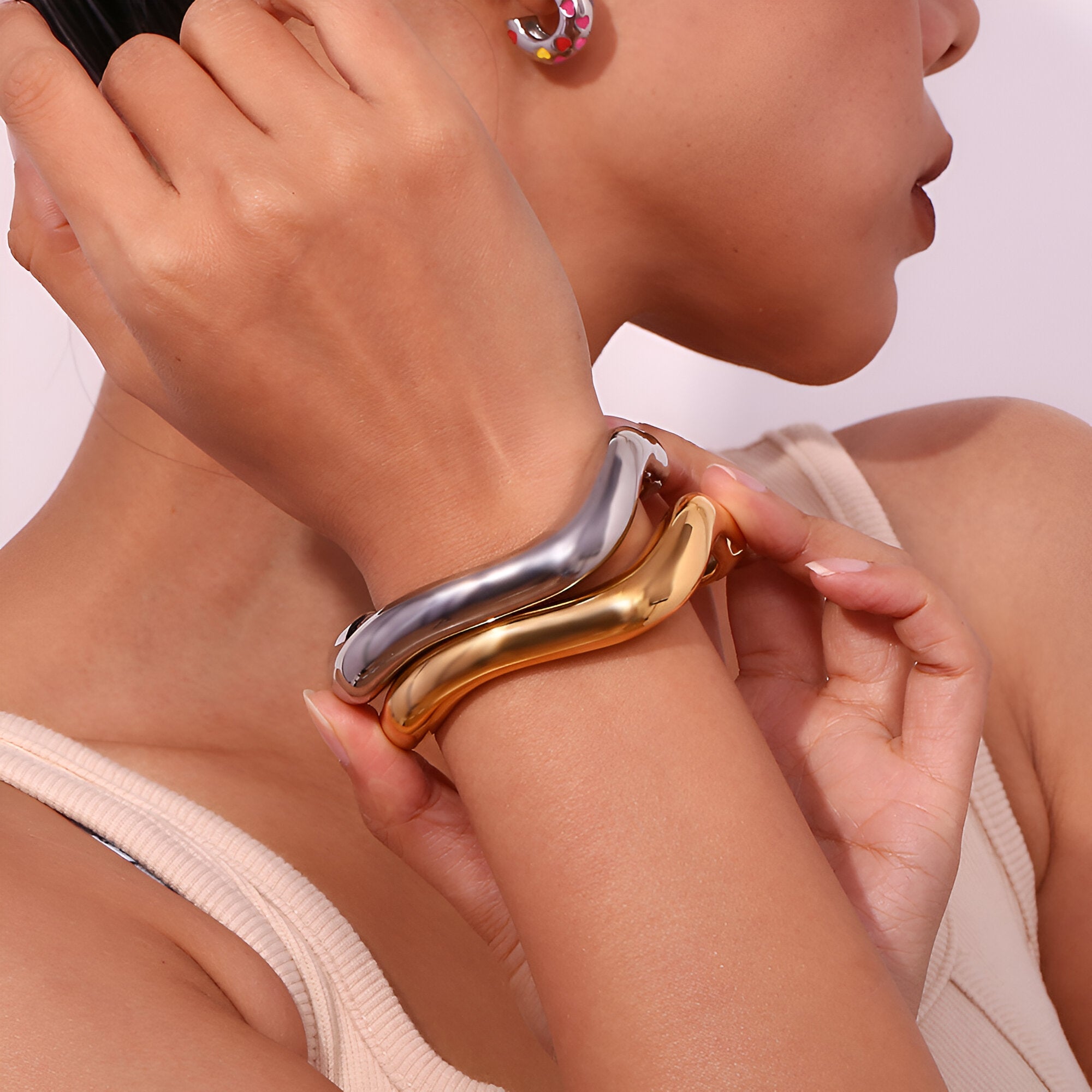 Bracelets jonc ondulés en acier inoxydable, finitions or et argent, style moderne et épuré.