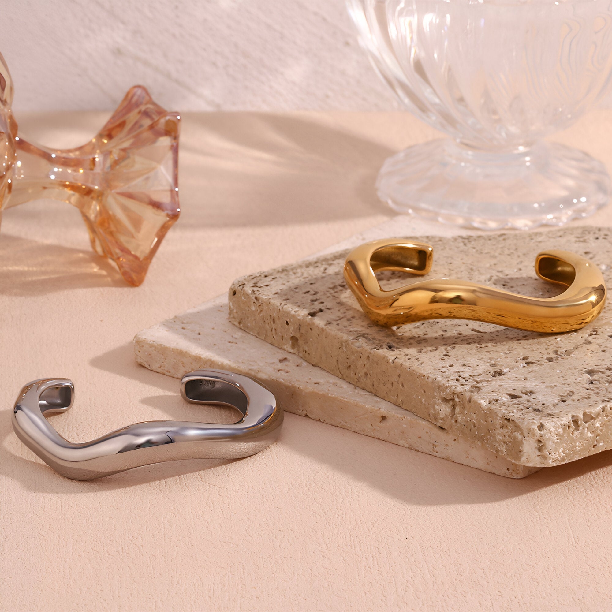 Bracelet jonc ondulé en acier inoxydable, finition dorée et argentée, design moderne et épuré.