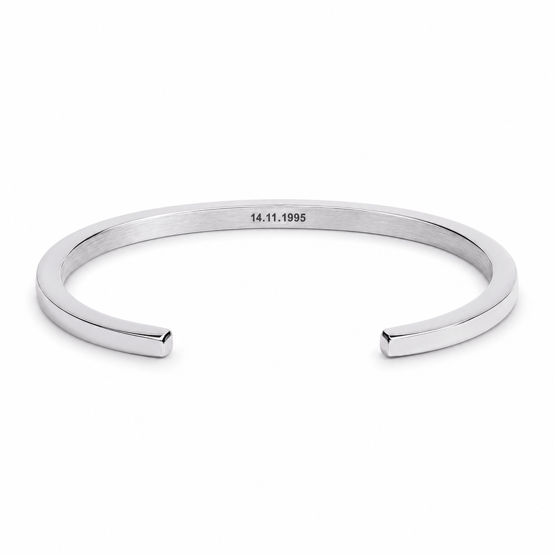 Bracelet jonc Vicky argent, gravure personnalisée 14.11.1995, posé de face sur fond blanc