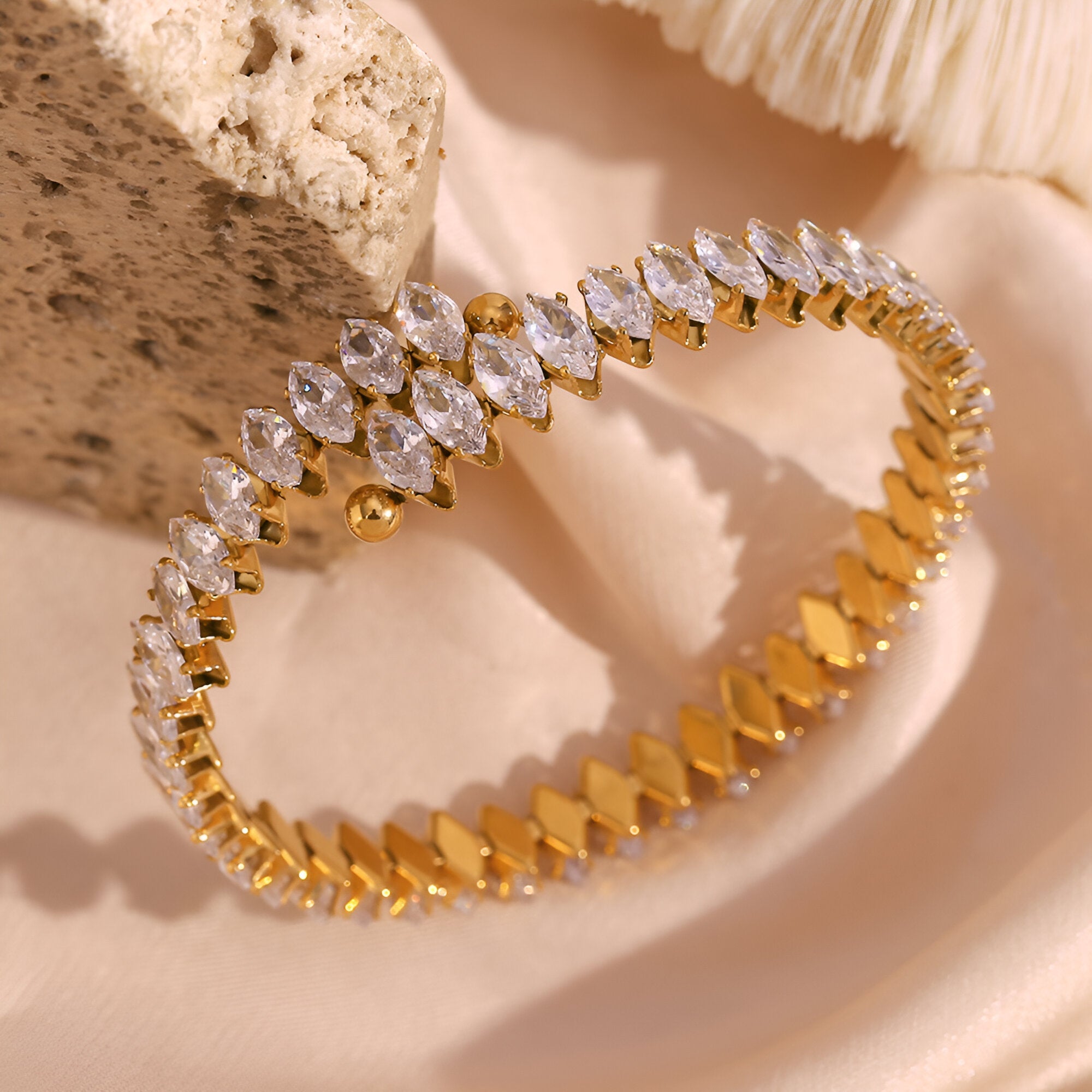 Bracelet jonc or en acier inoxydable avec rangée de pierres scintillantes marquise.