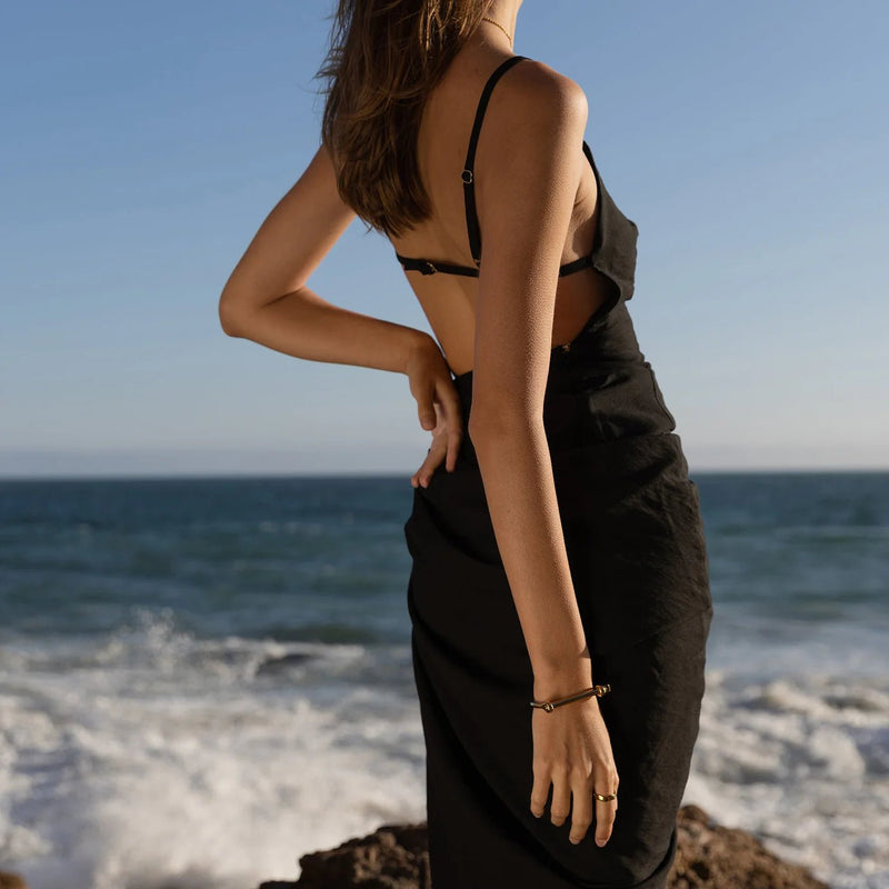 Bracelet jonc noir en titane style crochet d'ancrage porté au poignet, look élégant et minimaliste.