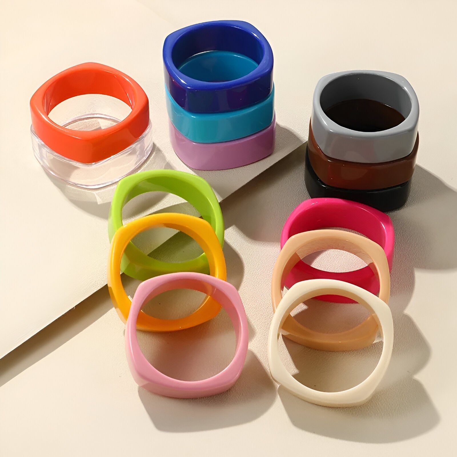 Collection de bracelets joncs larges en résine aux couleurs vives et variées, design épuré et moderne.